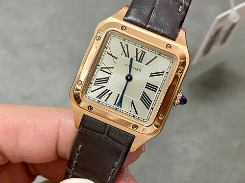 Cartier wristwatch: rose gold square case, white dial, Roman numerals, blue hands, black leather strap