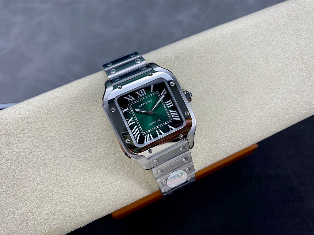 Stainless steel wristwatch with green dial on bracelet, angled view on cushion