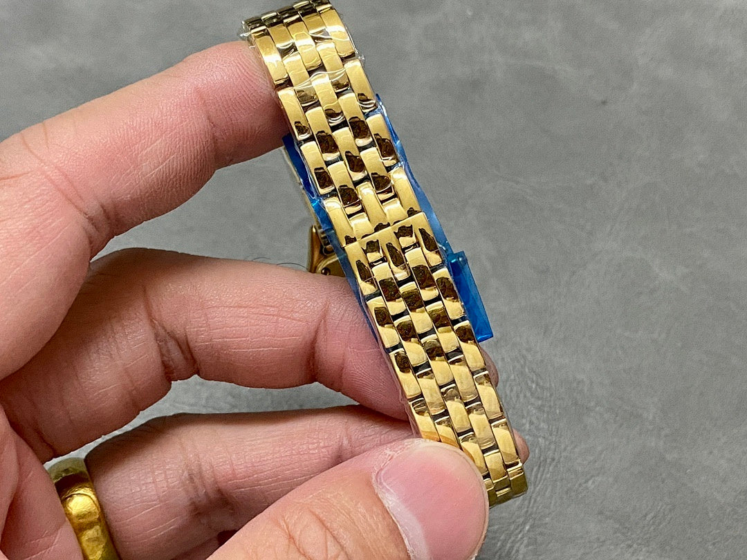 Gold-tone Cartier wristwatch band close-up on metal links from the side