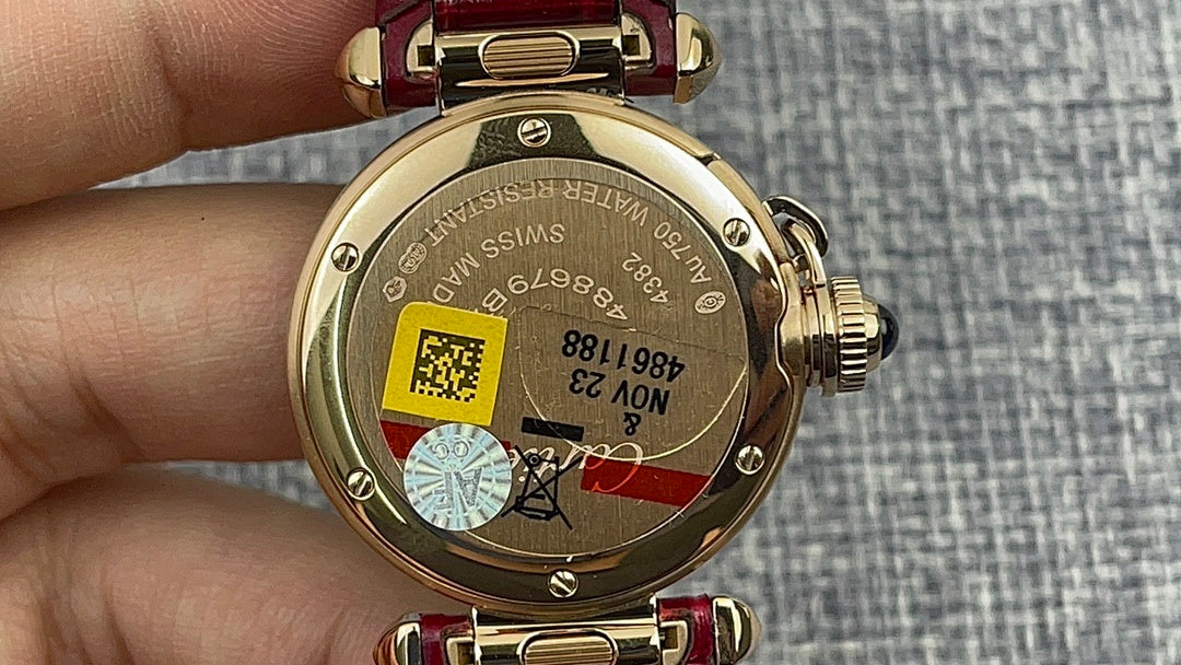 Cartier wristwatch case back with gold finish and red leather strap