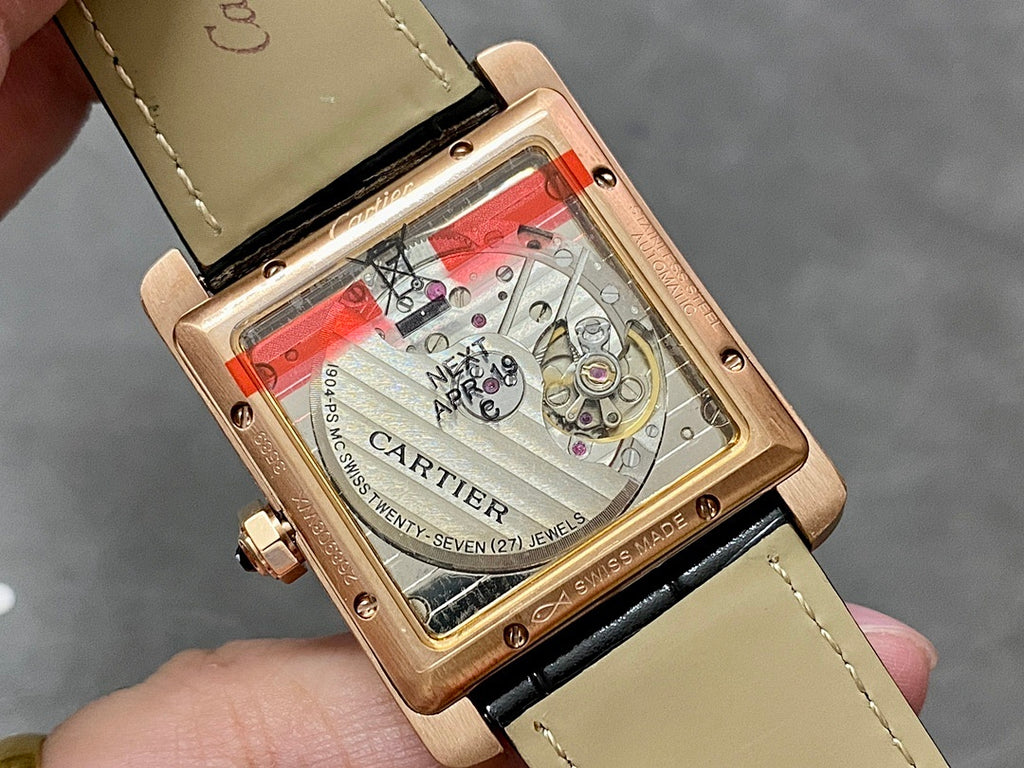 Cartier watch with transparent caseback showing Swiss movement, black strap