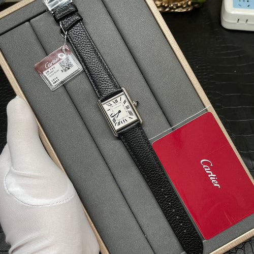 Cartier wristwatch in a box with black leather strap, silver case, white dial, red Cartier card.