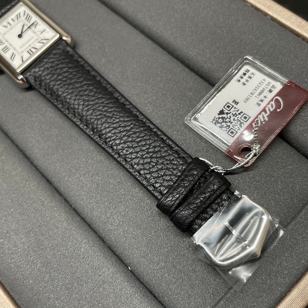Cartier wristwatch strap close-up with silver buckle clasp and product tag on black leather.