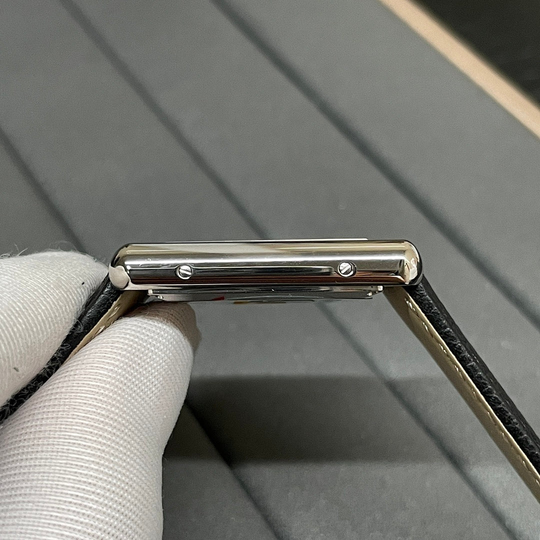 Cartier wristwatch side view showing the metal case bar and part of the black leather strap.