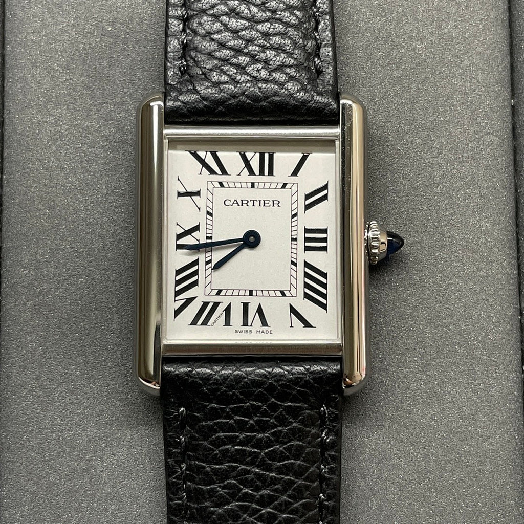 Square Cartier wristwatch with silver case, black leather strap, white dial and Roman numerals.