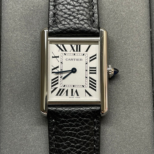 Square Cartier wristwatch with silver case, black leather strap, white dial and Roman numerals.