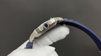 Cartier watch side view with blue strap and silver case, blue crown gem