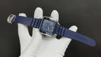 Cartier watch on blue strap with silver case and blue dial, hands visible
