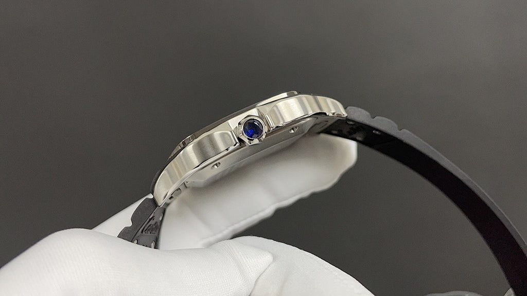 Cartier wristwatch top view with silver case and blue crown detail on black strap.