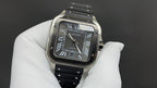 Cartier wristwatch with black dial, Roman numerals, and black leather strap.