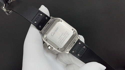 Cartier watch angled on black strap, showing engraved case back and clasp