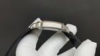 Cartier watch bezel and black strap close-up held in white-gloved hand