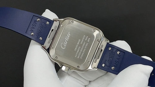 Cartier watch with engraved case back and blue leather strap, held on glove