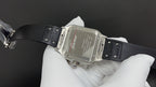 Silver-toned square wristwatch with black leather strap, clasp and red Cartier script