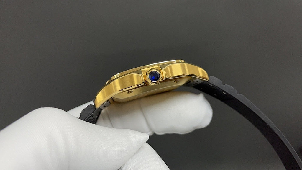 Gold Cartier watch side view with crown and blue gem, black strap attached