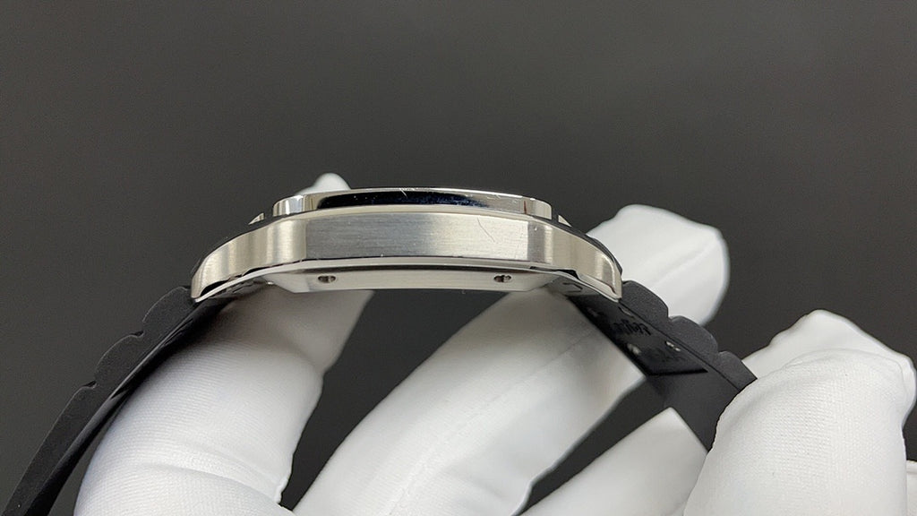 Cartier wristwatch side view with silver metal case and black rubber strap