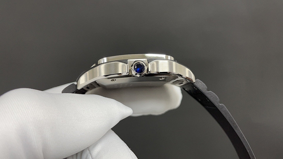 Cartier wristwatch crown with blue gemstone on silver case, black rubber strap
