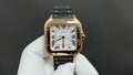 Cartier watch with gold-toned case, black strap, white roman numeral dial