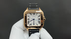 Cartier watch with gold-toned case, black strap, white roman numeral dial