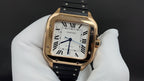 Cartier watch front view with gold-toned case, black strap, white roman numeral dial