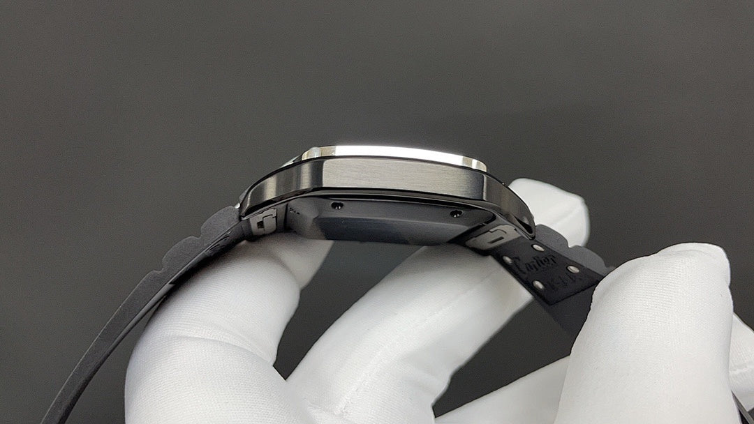 Cartier watch underside with black strap and metal case, held by white gloves.