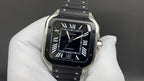 Men's Cartier watch with black Roman-numeral dial, steel case, and black leather strap