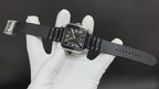Cartier watch with black leather strap, steel case, and black Roman numeral dial