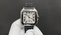 Cartier watch with square silver case, Roman numeral dial, black leather strap.