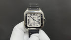 Cartier watch with square silver case, Roman numeral dial, black leather strap.