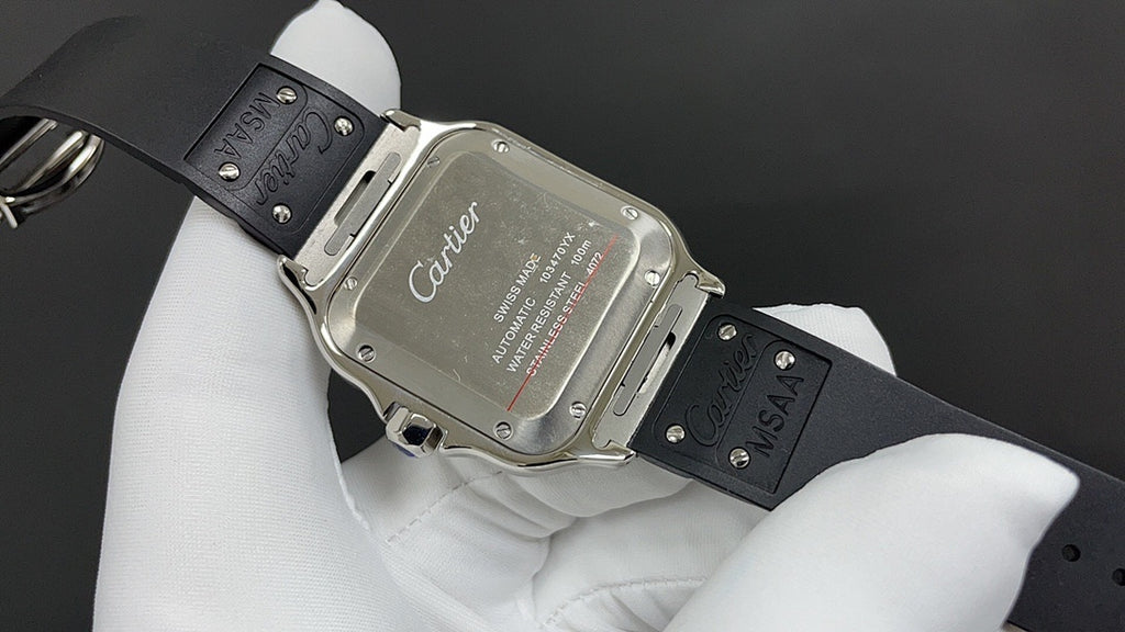 Cartier watch caseback with engraved markings and black leather strap on hand.