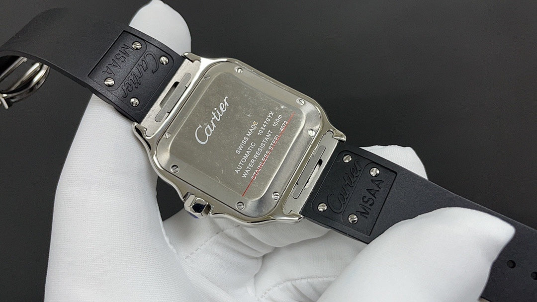 Cartier watch caseback with engraved markings and black leather strap on hand.