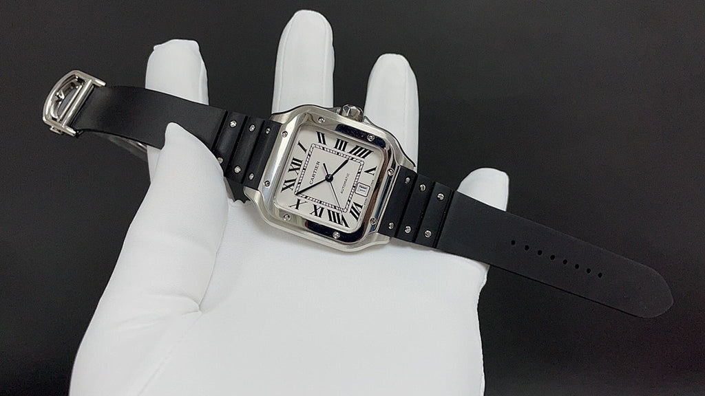 Cartier watch angled on glove, square Roman numeral dial and black leather strap.