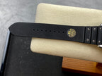 Black rubber watch strap with metal studs and clasp on the case side