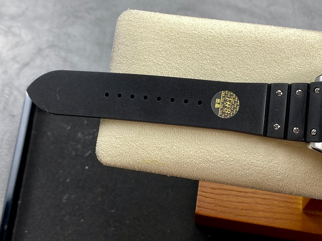 Black rubber watch strap with metal studs and clasp on the case side