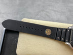 Cartier wristwatch black strap with multiple adjustment holes and gold-toned emblem on the buckle area.