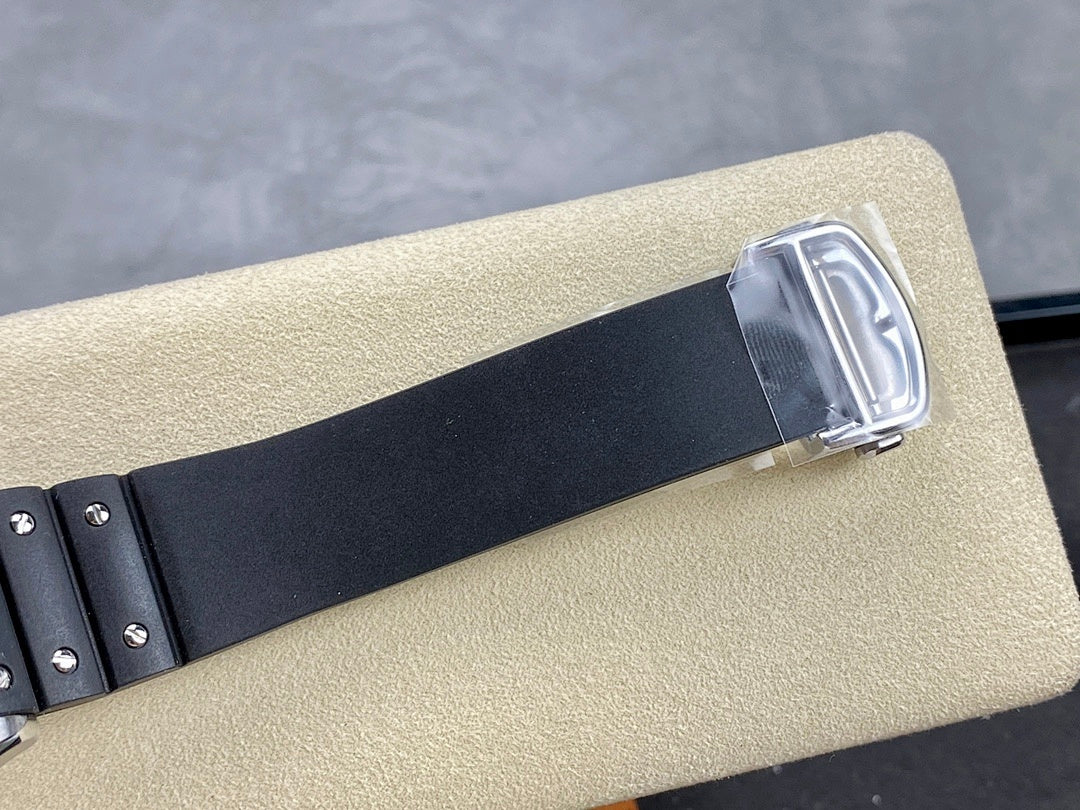 Cartier wristwatch with black strap and silver-tone buckle clasp on a tan display support.