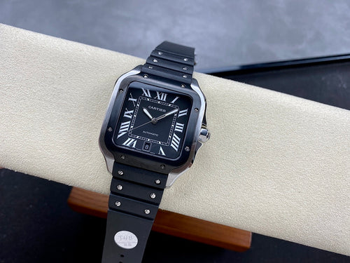 Cartier wristwatch with black dial, Roman numerals, and black link bracelet on a tan strap holder.
