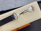 Wristwatch clasp and buckle detail on dark strap with polished metal hardware