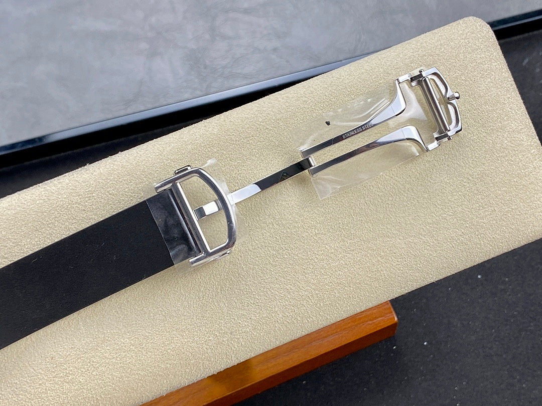 Wristwatch clasp and buckle detail on dark strap with polished metal hardware