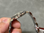 Cartier watch side profile with silver metal case and polished bezel