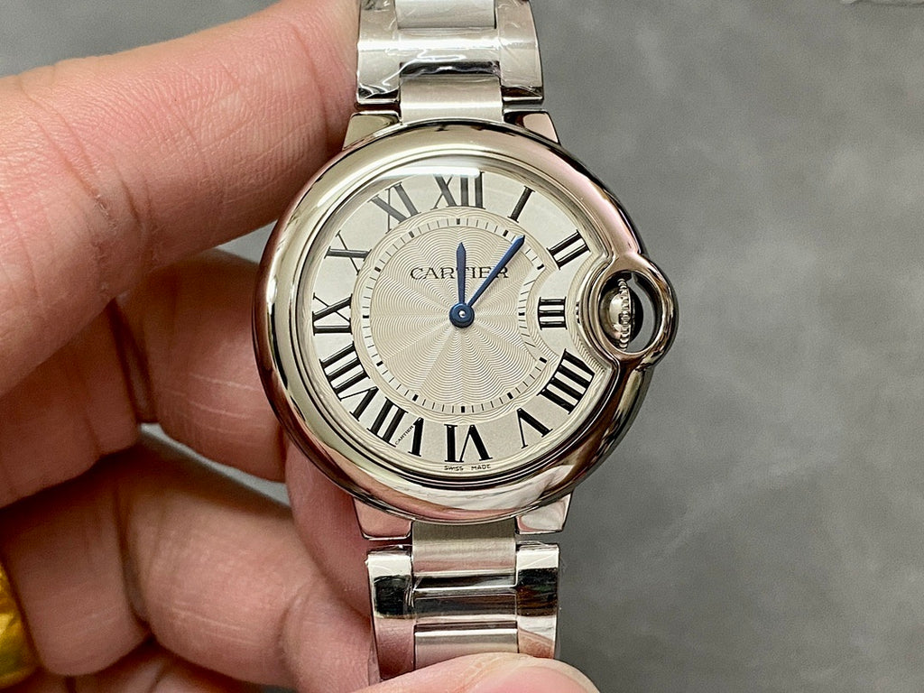 Cartier watch front with silver round case, Roman numerals, and blue center seconds hand