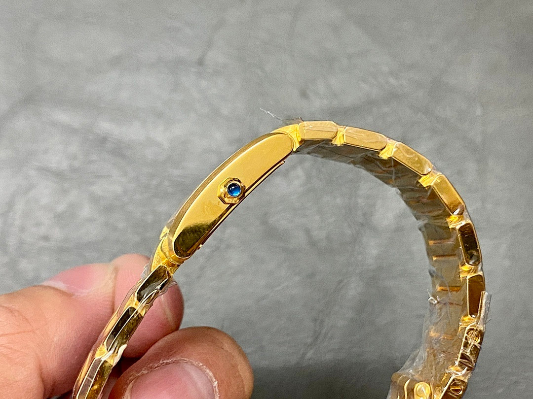 Gold-tone Cartier watch with jeweled crown and linked metal bracelet