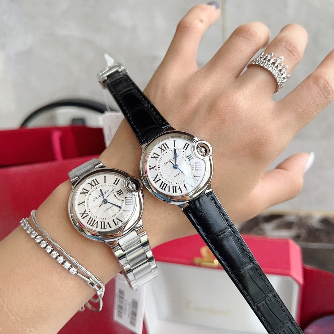 Two wristwatches on hand: stainless steel bracelet watch and black leather strap watch.