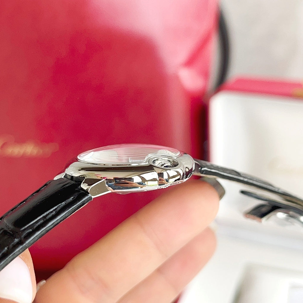 Stainless steel wristwatch with black leather strap and chrome crown detail.