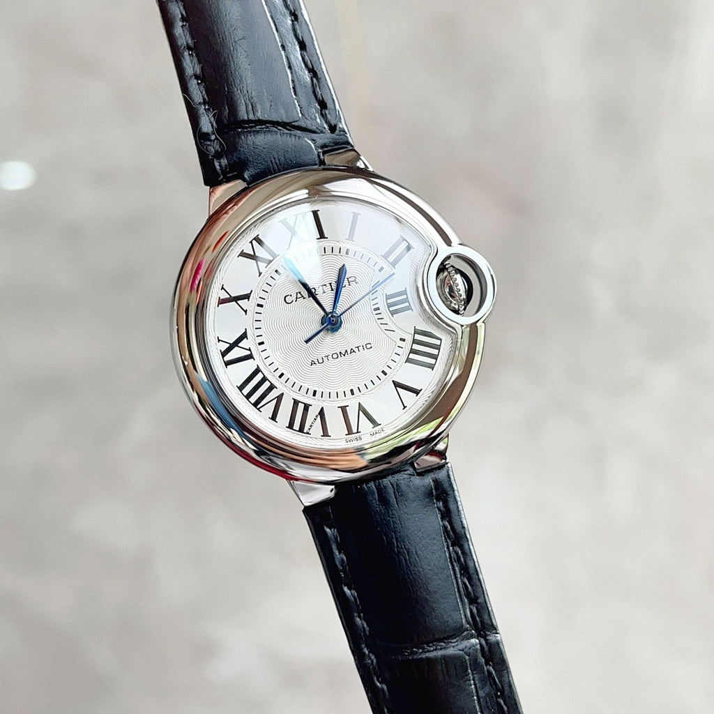 Black leather strap wristwatch with white Roman-numeral dial and round crown.