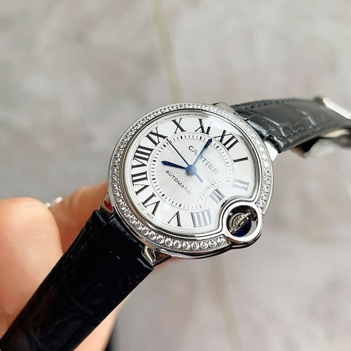 Cartier Ballon Bleu watch with black leather strap, white dial, blue hands, diamond bezel