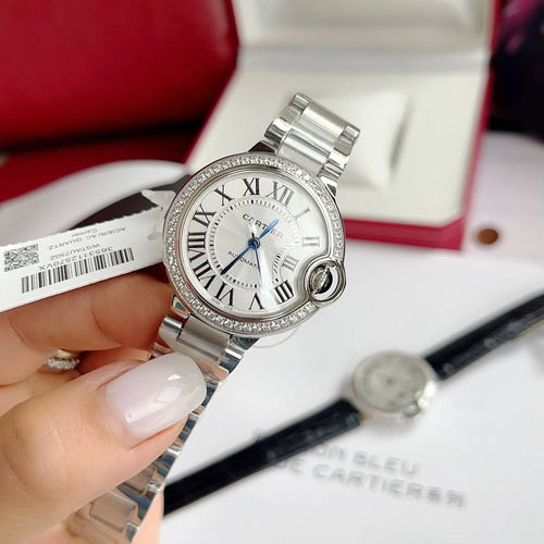 Cartier Ballon Bleu watch with silver link bracelet, white dial, blue hands, diamond bezel
