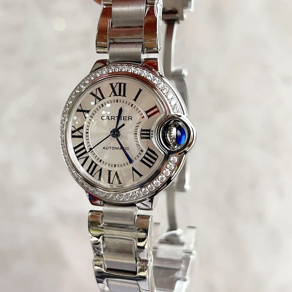 Cartier Ballon Bleu watch with silver bracelet, white dial, blue hands, diamond bezel