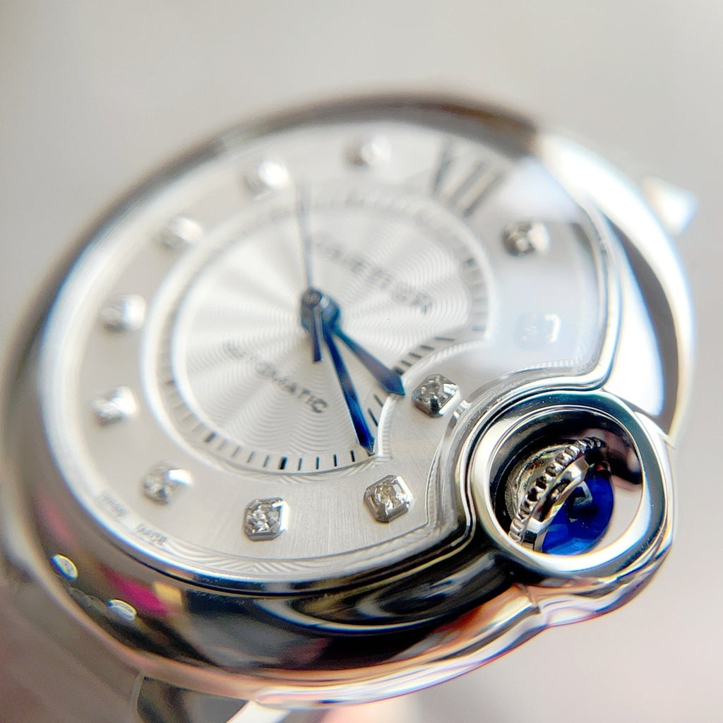Round watch with silver dial, Roman numerals, blue hands, and polished crown detail