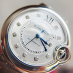 Close-up of Ballon Bleu watch dial with silver finish, blue hands, and diamond-like hour markers